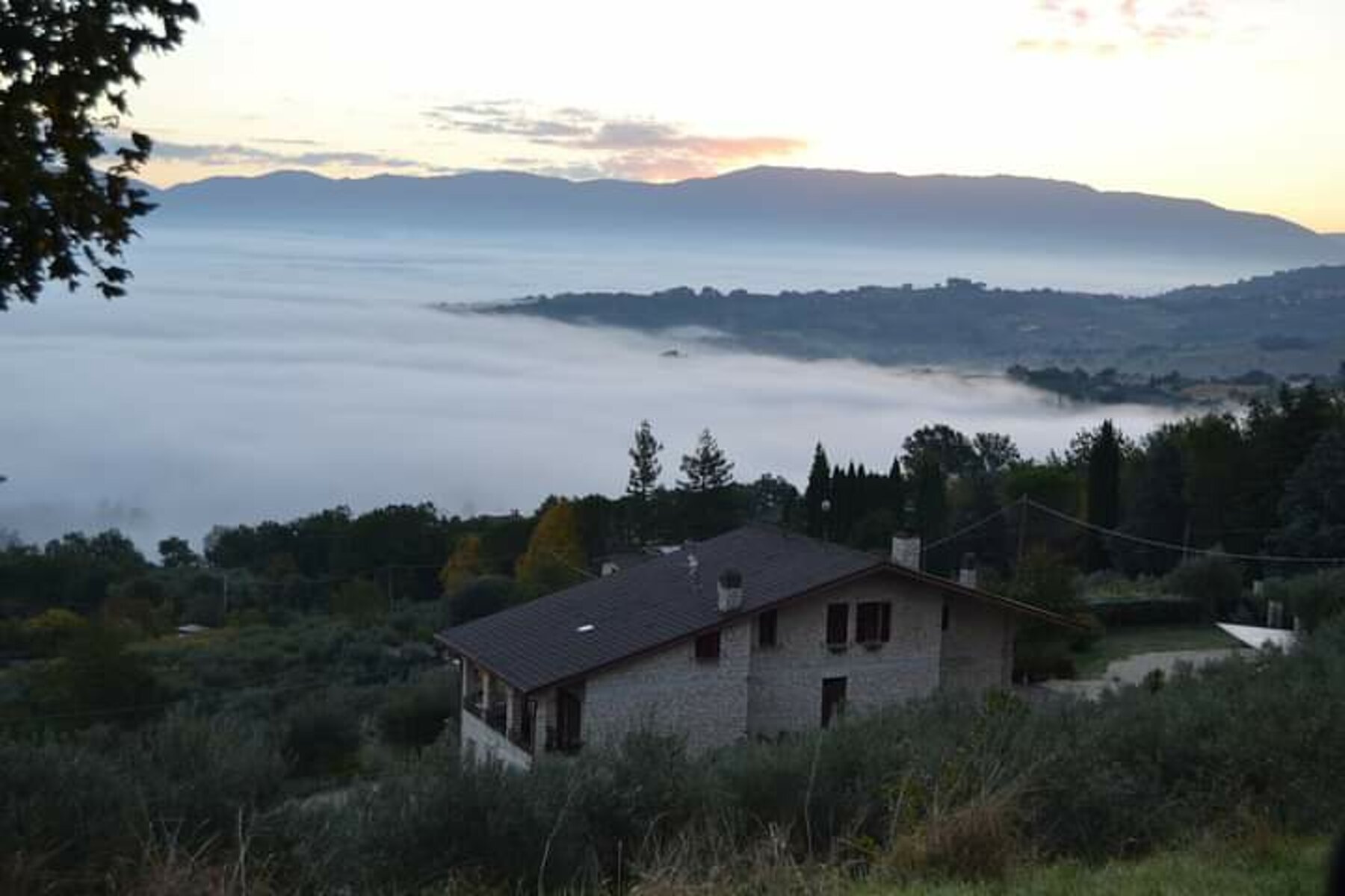 L'agriturismo all'alba, sopra la nebbia della valle
